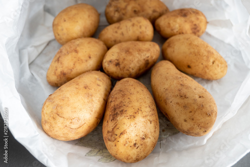 Obraz na płótnie Fresh russet potatoes in white paper bag ready for cooking or baking