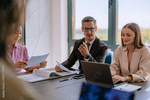 Business Meeting With Colleagues Discussing Strategy Around a Table in Modern Office Conference Room