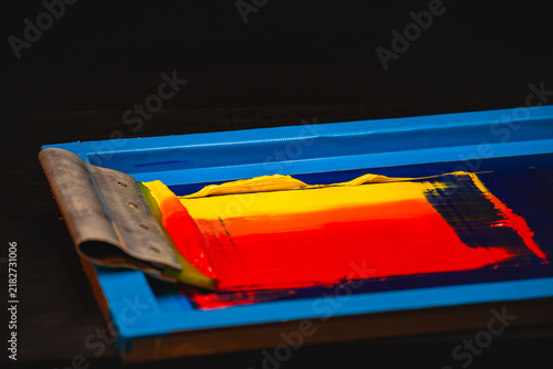 Konstfotografi The screen printing process captured in detail as bright inks transition from yellow to deep red across the mesh, emphasizing the skill and precision required to craft a stunning handcrafted print
