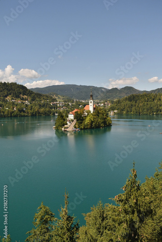 Scenic view of Lake Bled in Slovenia with island church, surrounded by mountains and calm turquoise water