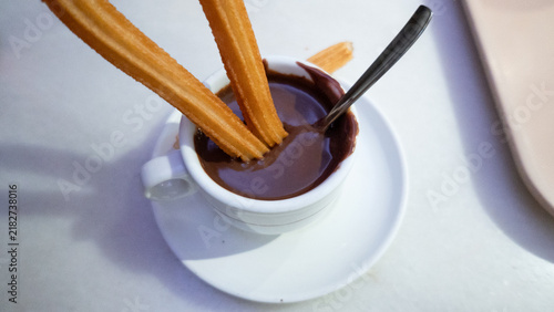 Churros dipping in hot chocolate for breakfast