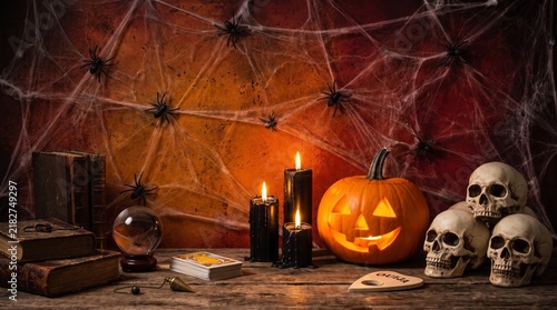 Spooky Halloween Still Life Featuring Carved Pumpkin Jack-o-Lantern Candles Skulls and Cobwebs on a Rustic Wooden Table for Festive Haunted Atmosphere