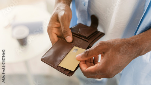 Bild auf Leinwand Focused Unrecognizable Man Holding Credit Card While Opening Leather Wallet At Home