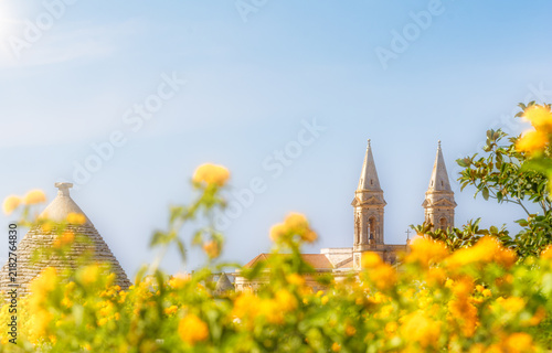 Basilique d'Alberobello et fleurs jaunes