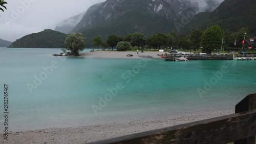 Beautiful turquoise mountain lake surrounded by dramatic low clouds after the rain.