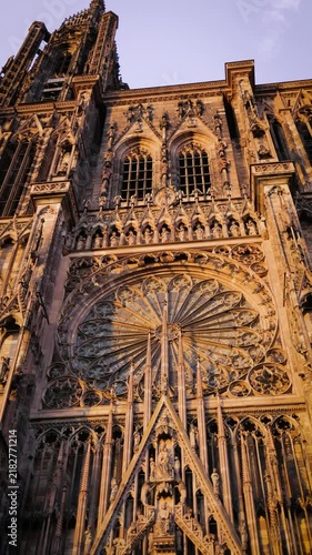 Close-up view of an impressive historic cathedral with detailed architectural patterns illuminated by warm sunset light.