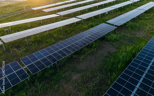 фотографія Solar panels aligned in rows generating power on hillside