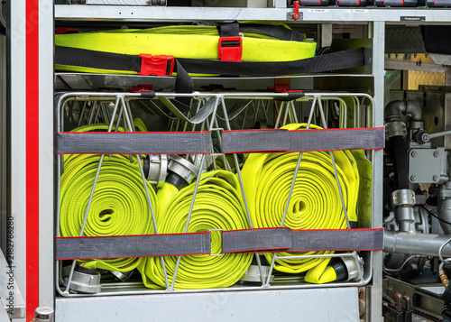 Konstfotografi Rolled yellow fire hoses organized inside a modern fire engine truck compartment