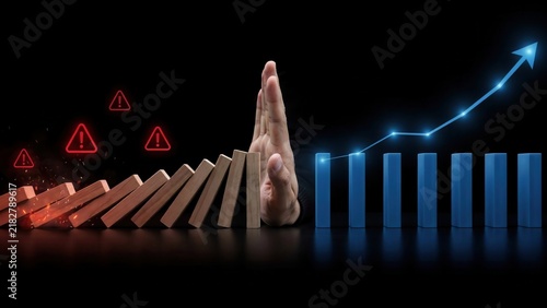 Hand stopping falling dominoes to protect growth and business success
