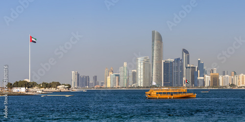 Abu Dhabi skyline with skyscrapers and Dhow boat at sea panorama in Abu Dhabi, United Arab Emirates