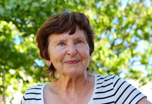 Serene portrait of an authentic senior woman in a summer garden