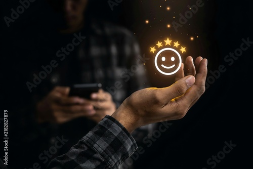Hand holding a floating five star customer satisfaction icon for service quality evaluation