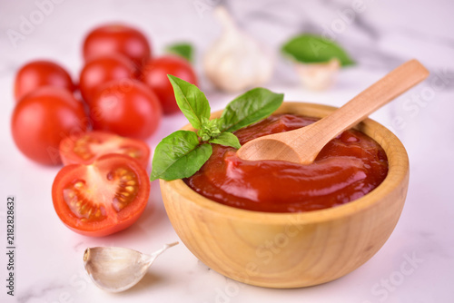 Bild auf Leinwand Tomato sauce in a wooden bowl on a white background. Close-up.