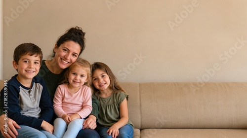 Happy mother and three children sitting together on a sofa at home