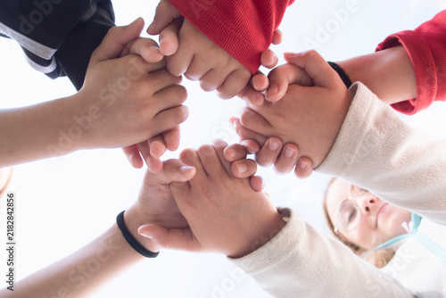 Children hold hands; the concept of friendship, unity, teamwork, and support.