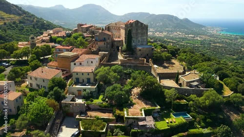 Pigna Corsica drone flight authentic hilltop village red tile roofs swimming pools, scenic Balagne coastline and Mediterranean sea panorama . Most beautiful villages France