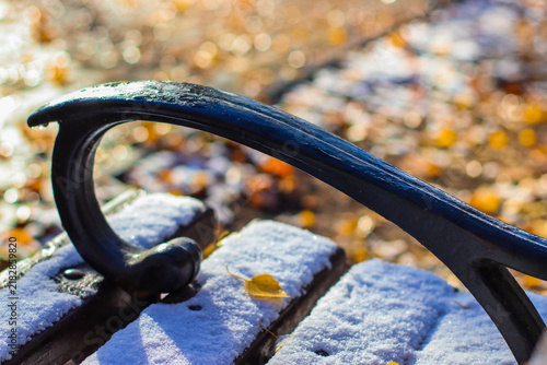 Canvastavla Close-up of a metal armrest on a snowy wooden park bench