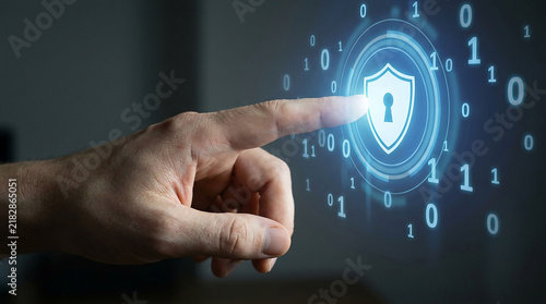Digital Security Hand: A close-up of a hand touching a glowing blue digital interface, symbolizing cybersecurity, data protection.