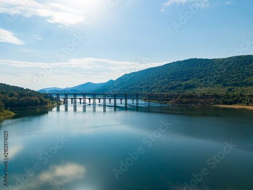 Foto Scenic bridge structure over calm water with mountains in the background during