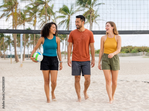 Group of people walking on beach after playing Volleyball