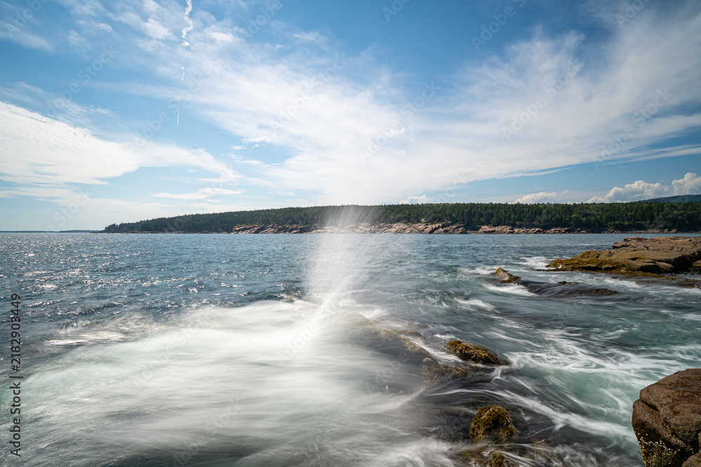 Fototapeta premium Ocean water spraying upward off granite rocks along the rocky coast at Otter Point in Acadia National Park on Mount Desert Island, Maine.