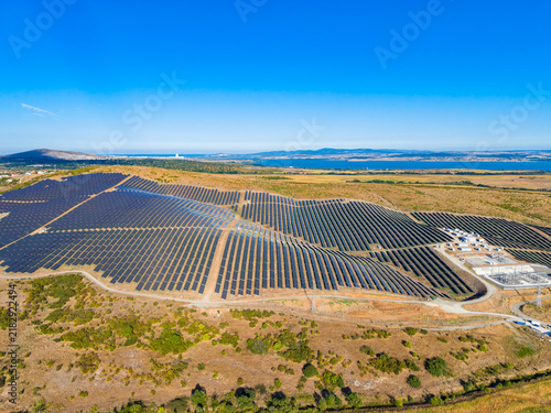 Фотография Solar farm installation located in a rural area with numerous solar panels cover