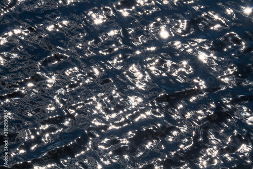 Obraz na płótnie Abstract water surface filled with luminous reflections and restless motion