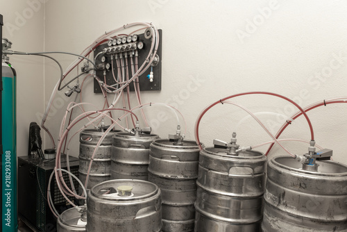 Photography Stainless steel kegs connected to a gas manifold system with lines and pressure