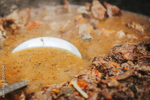 Фотография Close-up view of simmering beef stew with vegetables and spices in a large pot,