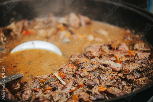 Obraz na plátně Close-up of simmering beef stew with tender meat pieces and vegetables in a larg