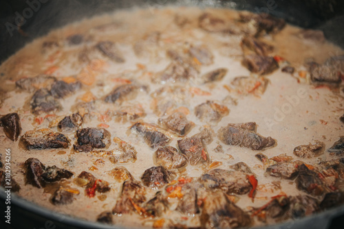 Quadro su tela Close-up of simmering beef chunks in a rich sauce with spices, steam rising from