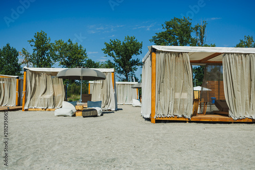 Quadro su tela Beach resort with cabanas by the water during the sunny day in summer