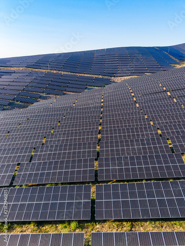 Принти на полотні Solar panel farm located in a wide open area with rows of solar panels aligned i