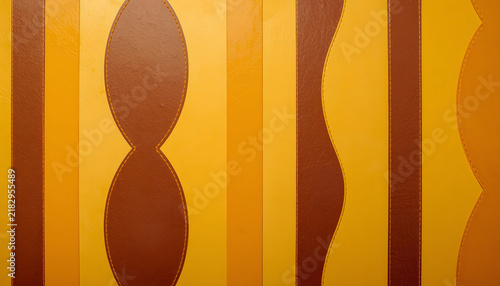 Abstract vertical stripes in yellow, orange and brown with curved hourglass-like geometric forms
