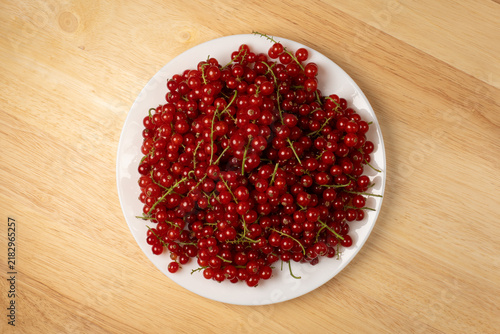 Fotografía Red currants filling white plate for healthy eating