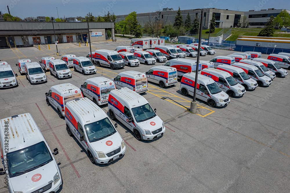 Fototapeta premium Canada Post delivery vans in a Toronto parking lot. The Crown corporation is ending door-to-door delivery for community mailboxes: Toronto, Ontario, Canada - May 17, 2026
