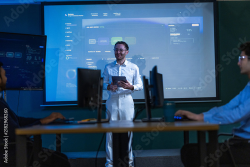 Картината върху платно A male innovation lead dressed entirely in white holding a black tablet smiles b