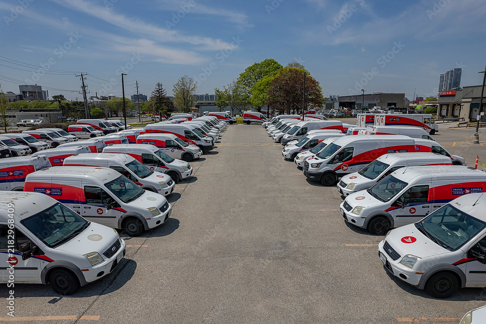 Obraz premium Canada Post delivery vans in a Toronto parking lot. The Crown corporation is ending door-to-door delivery for community mailboxes: Toronto, Ontario, Canada - May 17, 2026