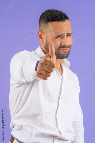 фотографія Young adult man pointing finger with skeptical expression