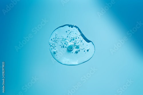 Clear serum liquid drop texture on blue background