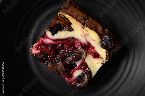 Close-up of delicious homemade cranberry cream cheese brownies on a dark background