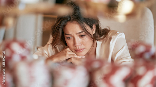 Distressed Woman Staring At Stacks Of Casino Chips