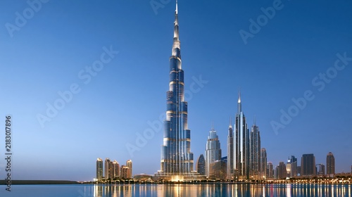 Towering skyscrapers illuminated against blue twilight sky over