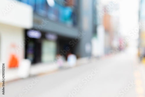 Abstract blurred urban local neighborhood street background with modern shop storefronts and clear road pavement