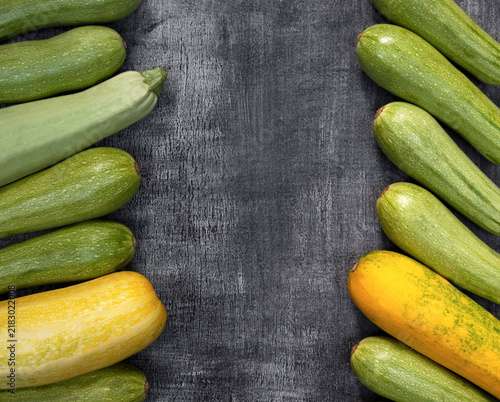 Several colorful zucchini on a wooden surface, showing organic farm produce for food, agriculture, retail, and seasonal content.