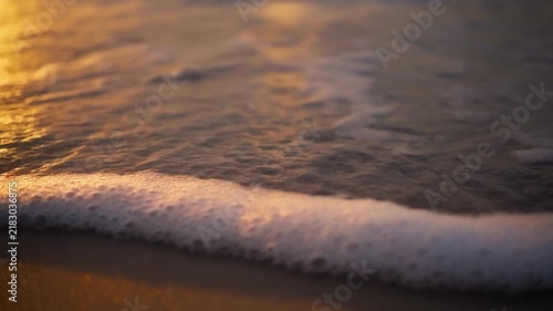Divine light coastal waves washing over golden sunset beach