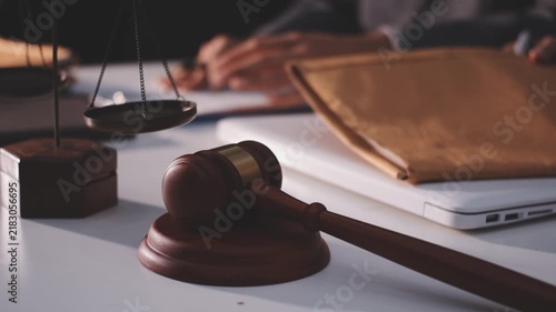Close-up of judge gavel and scales of justice on lawyer desk.