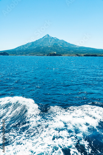 Cuadro en lienzo Mount Rishiri on Rishiri Island seen beyond ferry wake under clear blue sky
