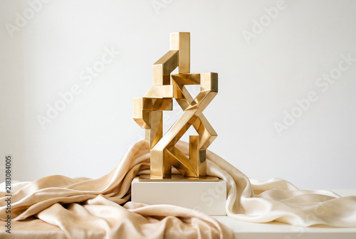Golden Geometric Sculpture With Fluid Silk Drapes In Bright Studio Setting Under Soft Diffuse Lighting