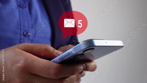 Hand grips modern smartphone with red notification icon